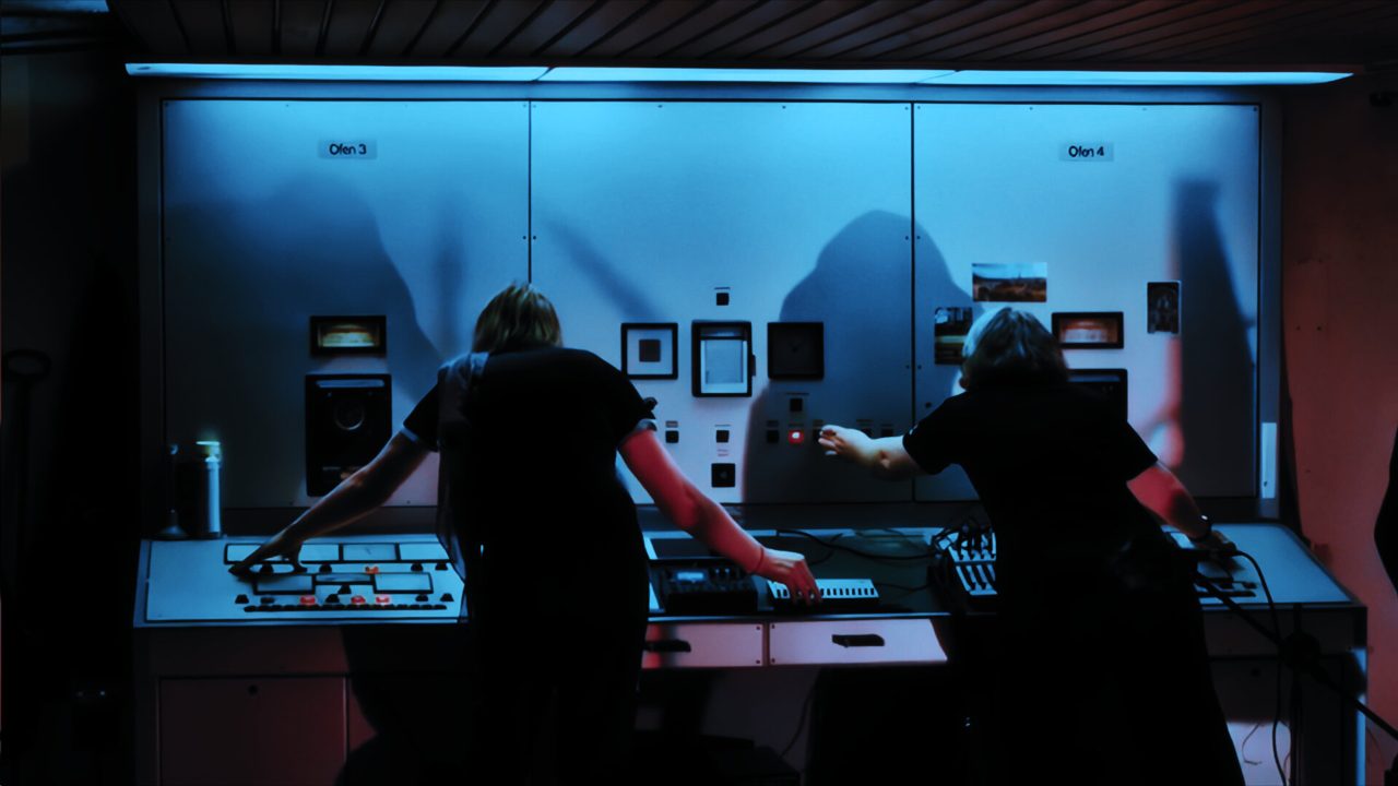 Catenation live, two performers at a blue-lit control panel