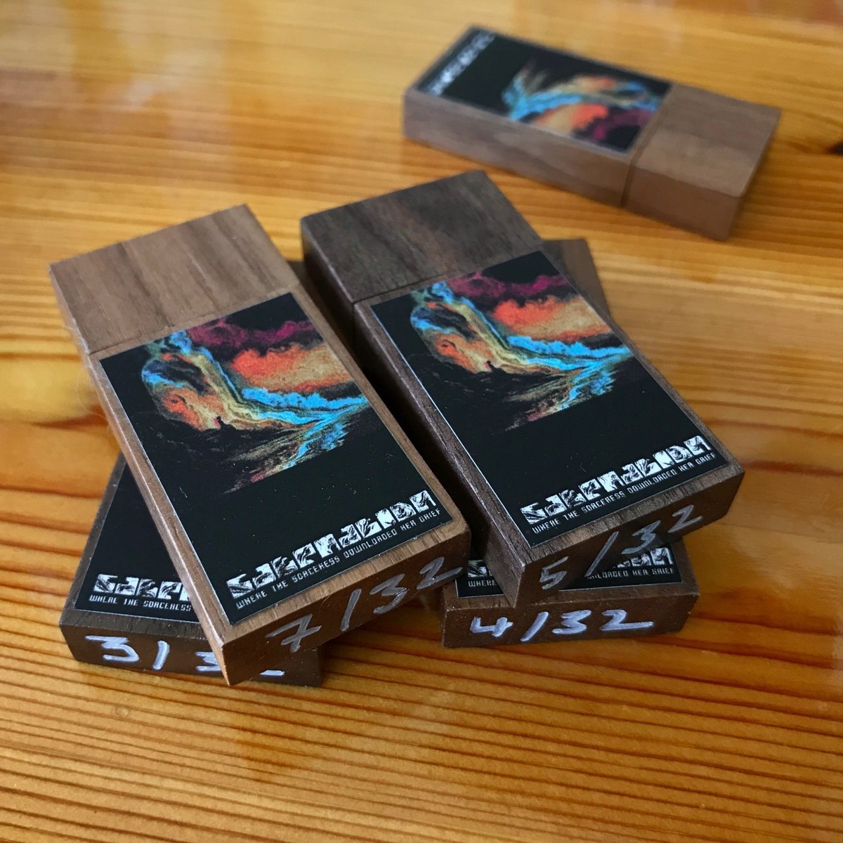 Hand-numbered walnut-wood USB drives of the album Where The Sorceress Downloaded Her Grief